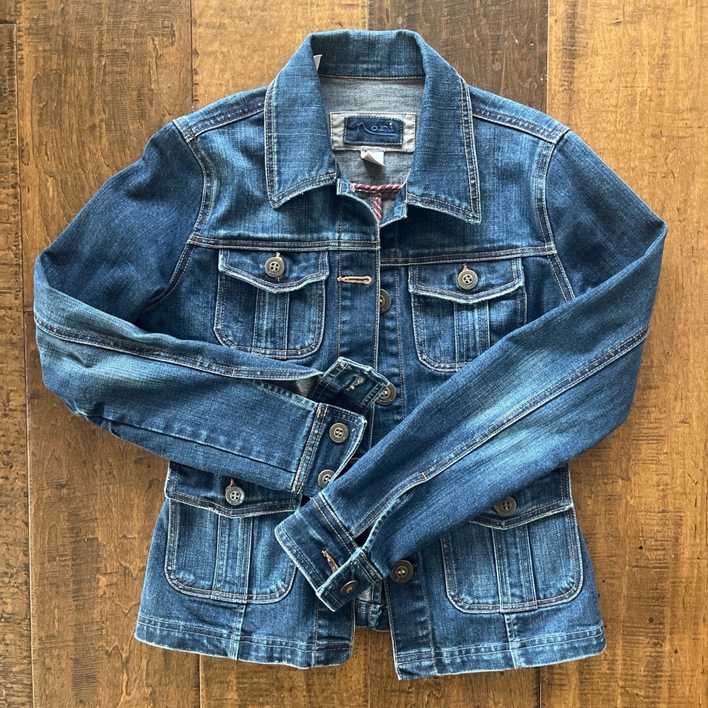 Dark wash fitted denim jean jacket with pockets, fitted straps and back vent